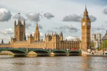 Photo showing Big Ben, London's iconic landmark, towering above the Palace of Westminster with the River Thames in the foreground.